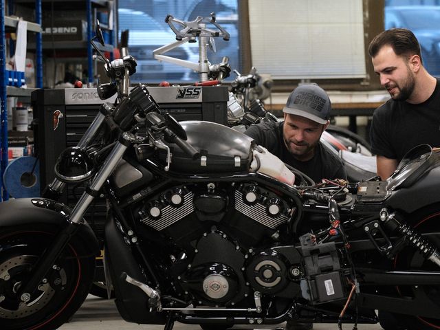 Zwei Mechaniker an einer Harley-Davidson V-Rod in der Werkstatt